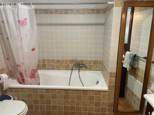 y baño con bañera y aseo. en Aventina Holiday Home, en Burcèi