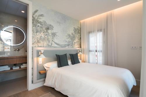a bedroom with a large white bed and a window at CISNES PALACE in Sanlúcar de Barrameda