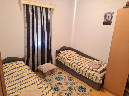 a bedroom with two twin beds and a window at Prenociste Melina in Sjenica