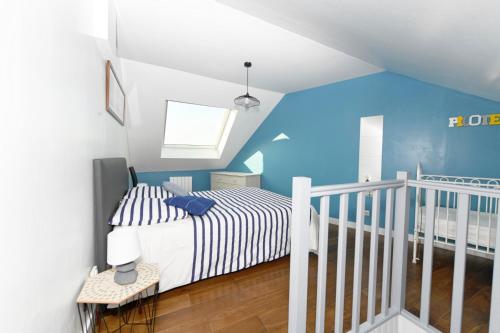 a bedroom with a bed and a blue wall at A l'Abordage in Fécamp