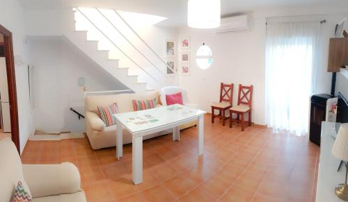 ein Wohnzimmer mit einem weißen Tisch und einer Treppe in der Unterkunft El Sueño del Bosque in El Bosque