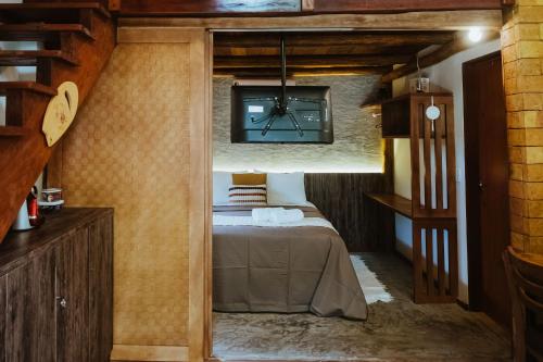 um quarto com uma cama num pequeno quarto em Vila do Porto, Praia do Patacho - Bangalô Milagres em Pôrto de Pedras
