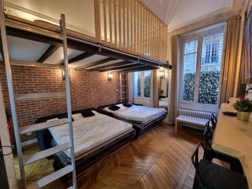- une chambre avec 2 lits superposés et un mur en briques dans l'établissement Beautiful mini Loft near Saint-Lazare, à Paris