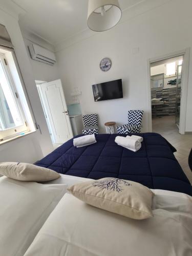 a bedroom with two beds with blue and white sheets at Casa Leucosia Suites in Capri