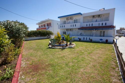 a large building with a yard in front of it at Villa Bel Passo Apartments in Kefalos