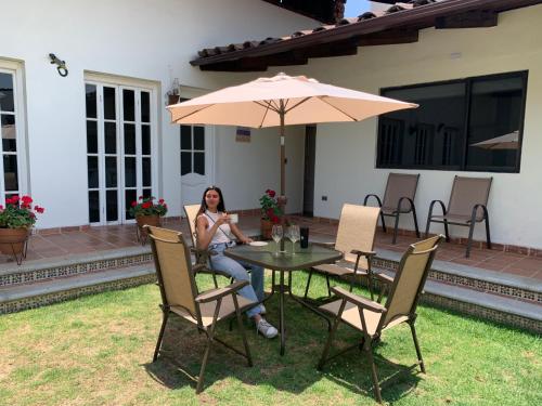 a woman sitting at a table with an umbrella at CASA SÁNCHEZ in Zacatlán