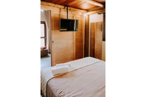 a bedroom with a bed and a flat screen tv at Vila do Porto, Praia do Patacho - Bangalô Patacho in Pôrto de Pedras