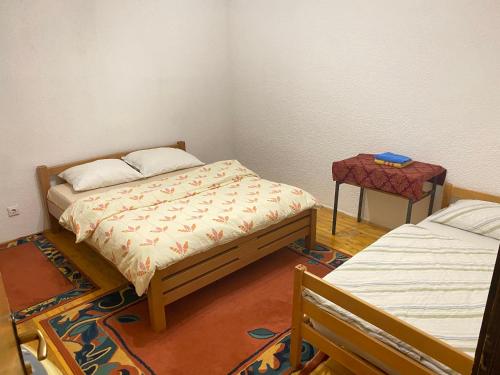 a small room with two beds and a table at Lav Apartments in Bihać