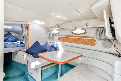 uma cozinha e área de refeições num trailer com uma mesa em yacht vedette Arlequin em Gruissan