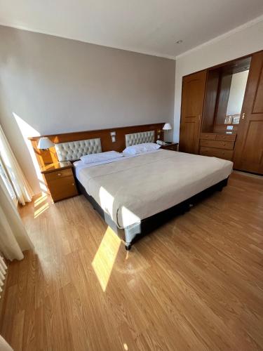 a bedroom with a large bed and a wooden floor at Bristol Hotel in Buenos Aires