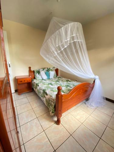 a bedroom with a bed with a mosquito net at Féfé in Vieux-Habitants