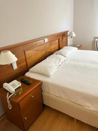 a bedroom with a bed and a phone on a night stand at Bristol Hotel in Buenos Aires