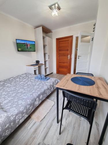 a bedroom with a bed and a table and a desk at Gościniec Joanna in Rajgród