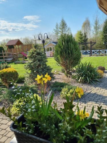 a garden with yellow flowers in a yard at Gościniec Joanna in Rajgród