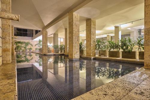 a lobby with a swimming pool with plants at Madisson Boutique Hotel Cartagena in Cartagena de Indias