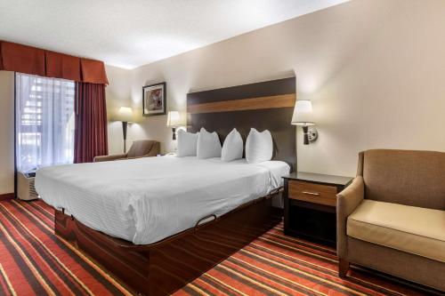 a hotel room with a large bed and a chair at Best Western Lindale Inn in Lindale