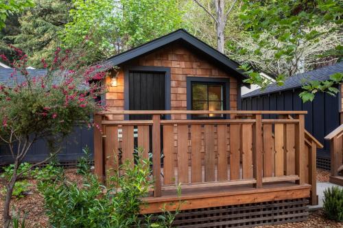 a small cabin with a deck in a garden at Dawn Ranch in Guerneville