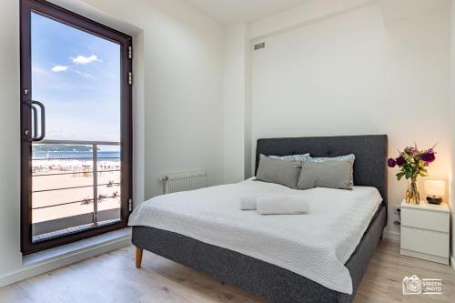 - une chambre avec un lit et une vue sur la plage dans l'établissement Plaża, à Sopot