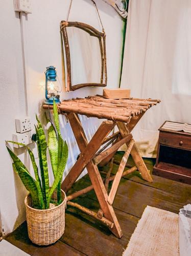 a wooden table with a chair and a potted plant at Camp Leopard - Yala Safari Glamping in Yala