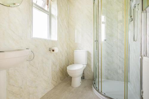ein Badezimmer mit Toilette und Glasdusche in der Unterkunft Stable Cottage in Ilfracombe