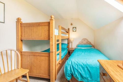 ein Schlafzimmer mit zwei Etagenbetten und einem Schreibtisch in der Unterkunft Stable Cottage in Ilfracombe