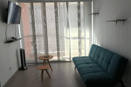ein Wohnzimmer mit einem blauen Sofa und einem Tisch in der Unterkunft Excelente Apartamento en Girardot in Girardot