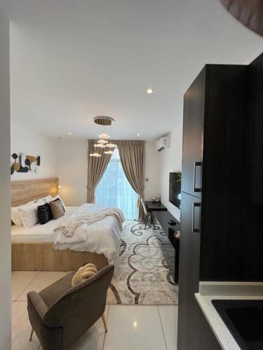 a bedroom with a bed and a desk and a chair at Embassy gardens Luxury suites CPG in Accra