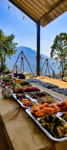 a table with several trays of food on at Neerville Waterfall Glamping- Neer waterfall in Shivpuri