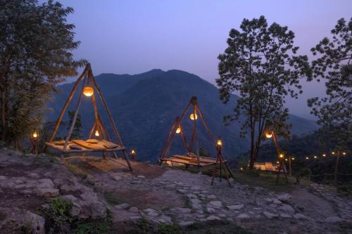 - un groupe de lits sur une montagne la nuit dans l'établissement Neerville Waterfall Glamping- Neer waterfall, à Shivpuri