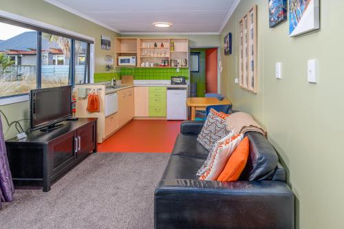 a living room with a couch and a kitchen at Kepler Mountain View in Manapouri