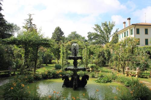 a fountain in the middle of a pond in a garden at Villa Leonati in Padova