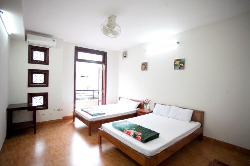 a room with a bed and a bench in it at Hồng Phát Hostel in Hue