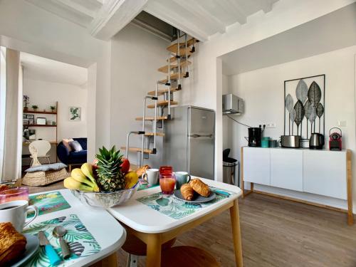 - une cuisine et un salon avec une table et un bol de fruits dans l'établissement Enjoy Bayeux #2 - Old town & WIFI, à Bayeux