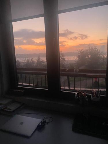 a view of a sunset from a window with a laptop at RiverView Homestay 2 in Xóm Ðé