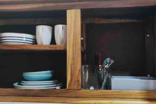 a wooden cabinet with plates and dishes in it at Puntarenas, Apartamento a 25 metros del mar, cerca del hospital in Puntarenas