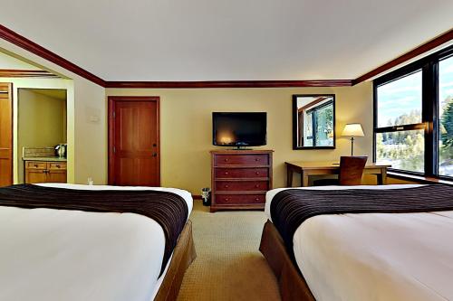a hotel room with two beds and a television at Resort at Squaw Creek's 605 in Olympic Valley