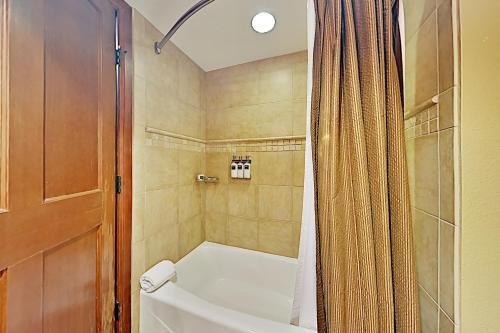 a bathroom with a tub and a toilet and a shower at Resort at Squaw Creek's 605 in Olympic Valley