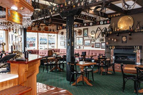 a restaurant with tables and chairs and a fireplace at Rutland Arms Inn in Whanganui