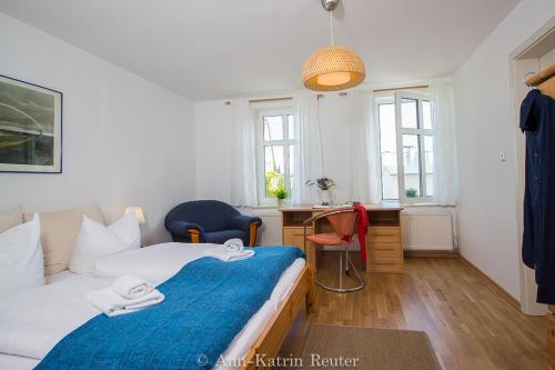 ein Schlafzimmer mit einem Bett, einem Schreibtisch und Fenstern in der Unterkunft Ferienhaus Am Ufer - Ferienwohnung Strandluft in Sassnitz