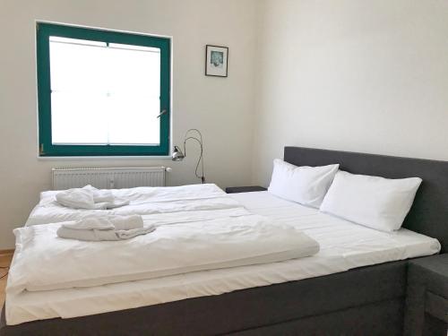 - un grand lit blanc avec 2 serviettes dans l'établissement Haus "Georgina" - Ferienwohnung 2, à Sassnitz