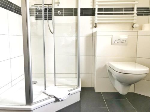 La salle de bains est pourvue d'une douche et de toilettes. dans l'établissement Haus "Georgina" - Ferienwohnung 2, à Sassnitz