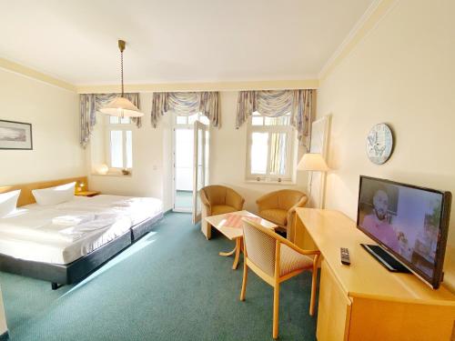 ein Hotelzimmer mit einem Bett und einem Schreibtisch in der Unterkunft Sassnitz - Villa Anna Villa Anna App 32 in Sassnitz