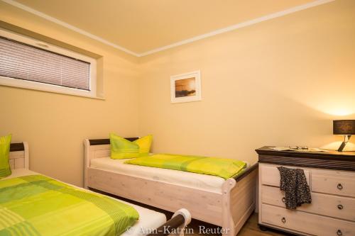 - une chambre avec 2 lits jumeaux et une commode dans l'établissement Lietzow Appartementhaus Möwe Haus Möwe - Ferienwohnung 2 "Fischmöwe", à Lietzow
