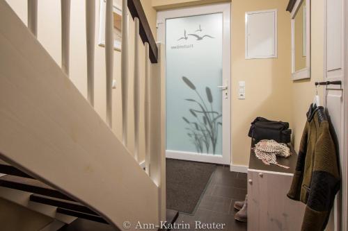 un couloir avec une porte en verre et un escalier dans l'établissement Lietzow Appartementhaus Möwe Haus Möwe - Ferienwohnung 2 "Fischmöwe", à Lietzow