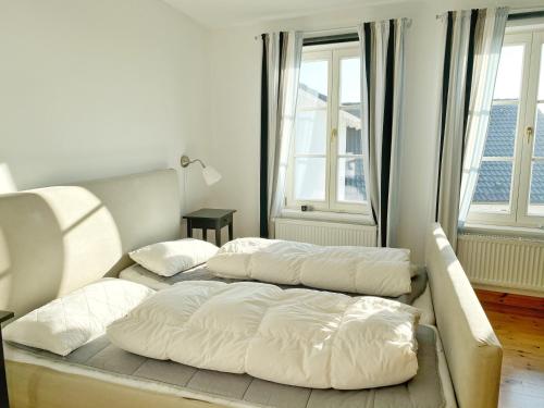 two beds in a living room with two windows at Sassnitz - Seaside Appartements Seaside Appartements, "Grey" in Sassnitz