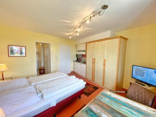 a bedroom with a large bed and a flat screen tv at Appartements am Rondell Neddesitz, Appartement 309 in Neddesitz