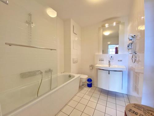 a white bathroom with a tub and a sink at Appartements am Rondell Neddesitz, Appartement 309 in Neddesitz