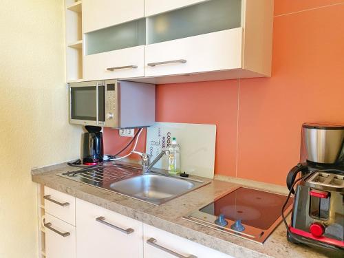 a kitchen with a sink and a microwave at Appartements am Rondell Neddesitz, Appartement 309 in Neddesitz