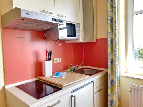 uma pequena cozinha com um lavatório e um micro-ondas em Appartements am Rondell Neddesitz, Appartement 307 em Neddesitz