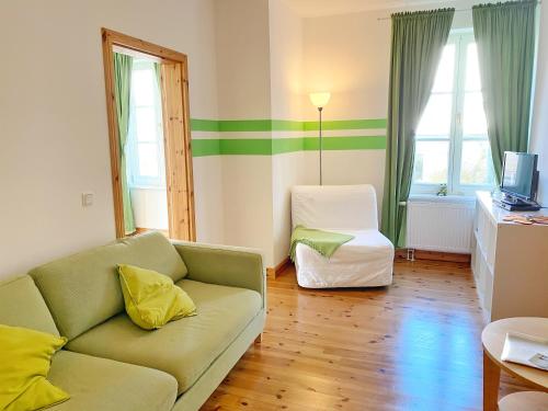 a living room with a couch and a chair at Sassnitz - Seaside Appartements Seaside Appartements, "Green" in Sassnitz
